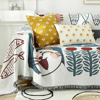 White knitted blanket with playful lucky cat, red and blue fish motifs, leaf patterns, and fringed edges by decorbites lucky cat