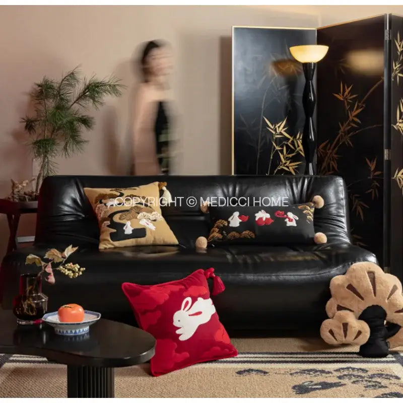 Black leather sofa with decorbites lucky rabbit embroidered throw pillows in silk velvet featuring pine forests design