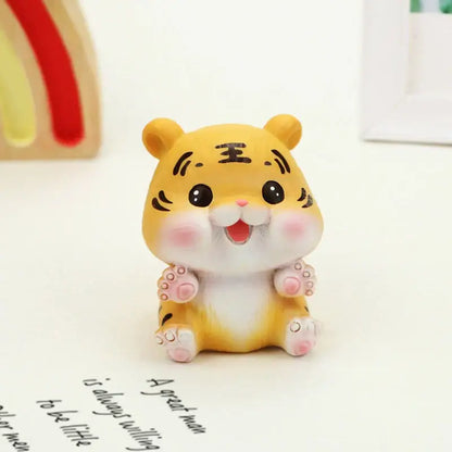 Cute yellow lucky tiger figurine with black whisker markings and pink cheeks sitting on a white surface by decorbites