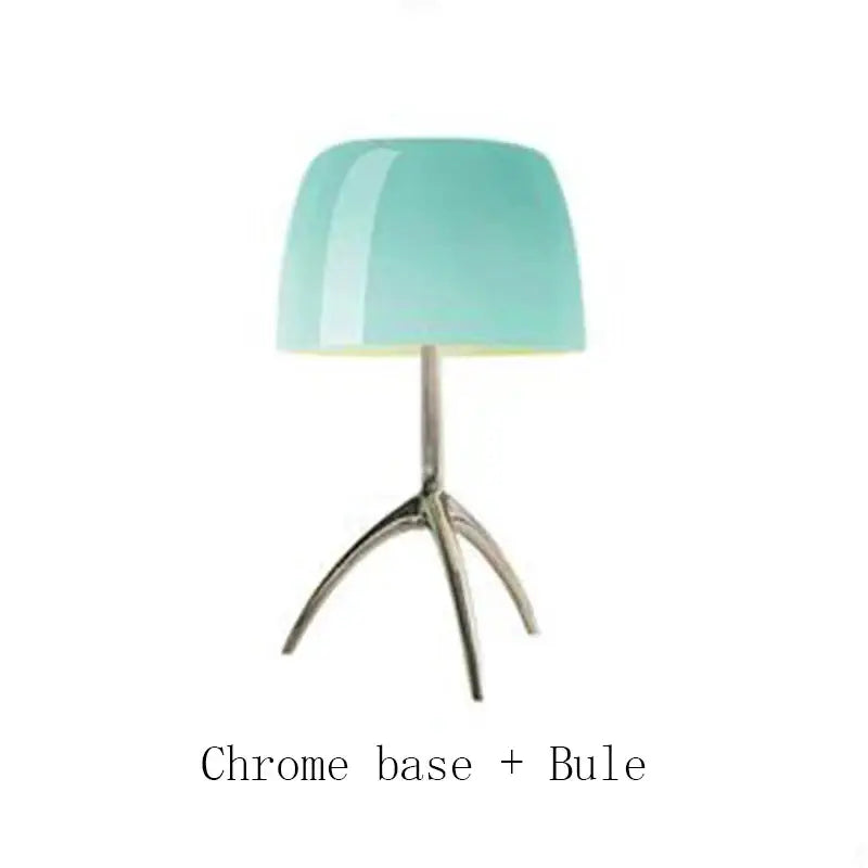 A decorbites lumiere piccola chrome table lamp with a glossy teal glass shade and polished chrome tripod base for bedside use