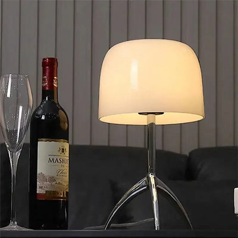 Modern chrome tripod table lamp with softly glowing off-white glass shade for bedside use decorbites lumiere piccola chrome
