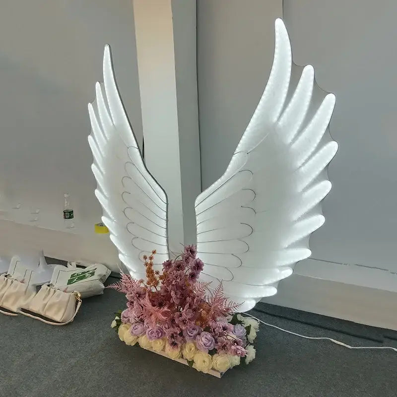 Illuminated white DecorBites luminescent angel wings lamp with glowing translucent material and intricate feather detailing