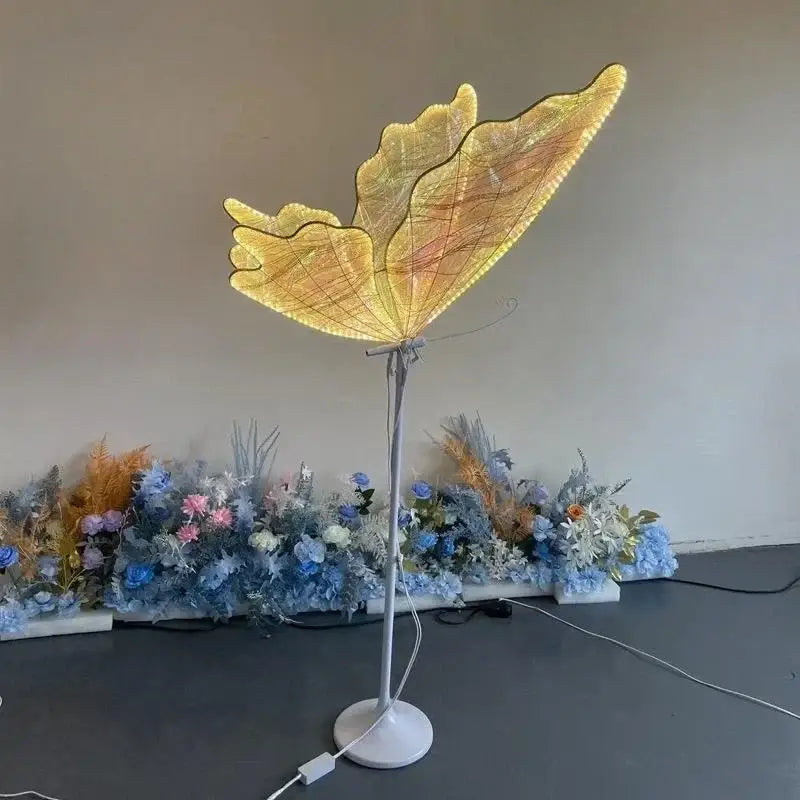 Golden butterfly-shaped floor lamp with illuminated wings and slender metallic stand decorbites luminescent butterfly led