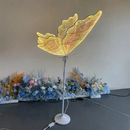 Golden butterfly-shaped floor lamp with illuminated wings and slender metallic stand decorbites luminescent butterfly led
