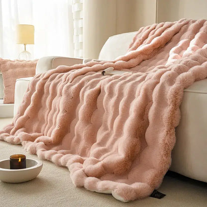 A soft pink decorbites luxe faux rabbit fur throw blanket with wavy ribbed texture for cozy autumn winter use