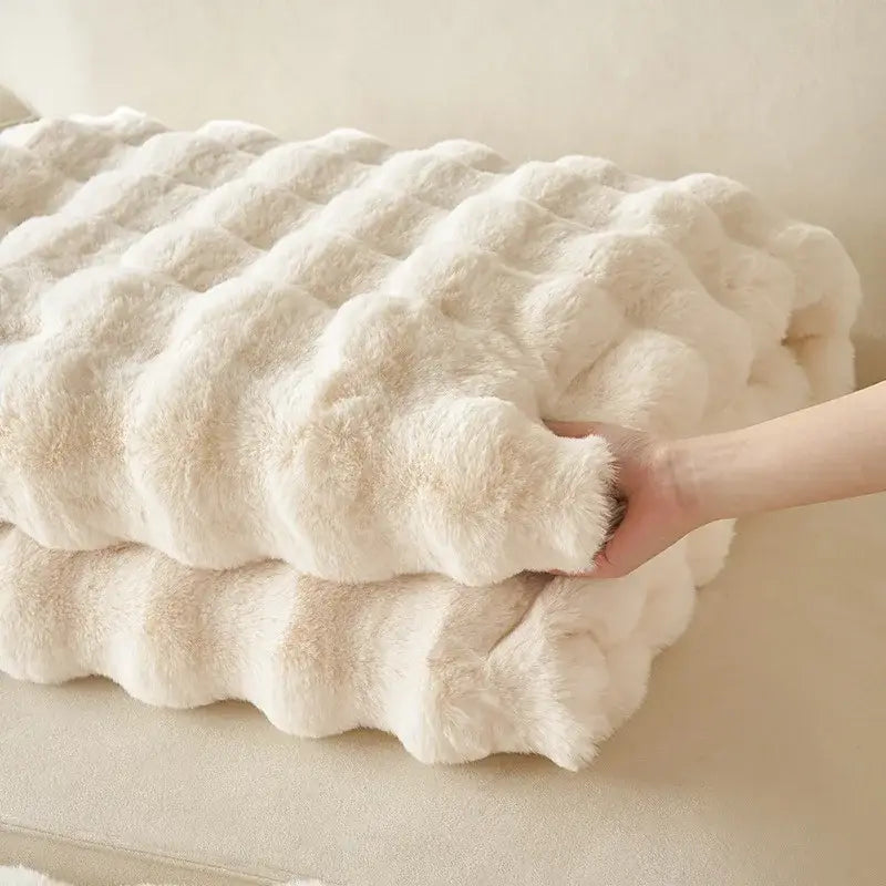 A plush off-white decorbites luxe faux rabbit fur throw blanket with quilted bubble texture for cozy autumn winter use