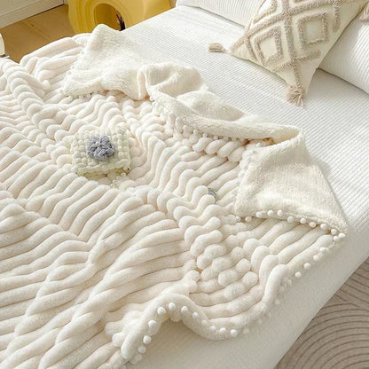 Cream-colored luxe faux rabbit weighted blanket with diamond pattern and white pom-poms for cozy autumn winter warmth