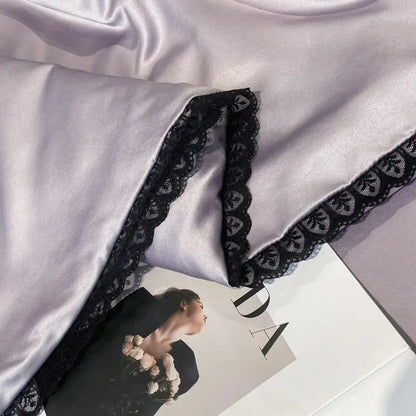 A soft lavender satin sleepwear piece with delicate black lace trim featured in the decorbites luxe flower quilt set