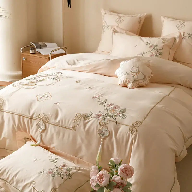Cream-colored satin duvet cover with delicate floral embroidery and gold-toned tassels from decorbites luxe flowers egyptian cotton bedding set