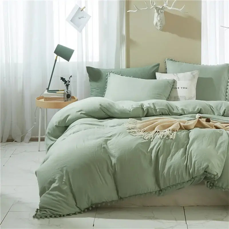 Soft sage green quilted bedding set with fluffy pom-pom trim from decorbites luxe furball tasseled collection