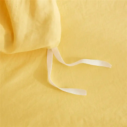 Soft yellow linen bedsheet with white elastic ties from decorbites luxe furball tasseled bedding set queen king size