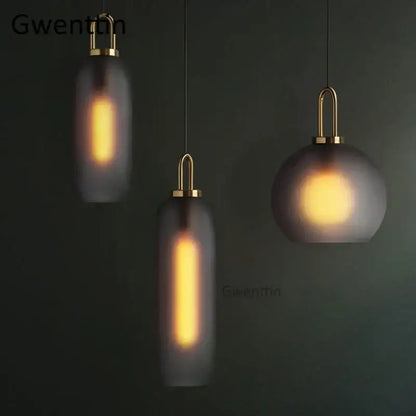 Three modern decorbites luxe glass ball pendant lights with frosted glass and brass finish emitting warm glow