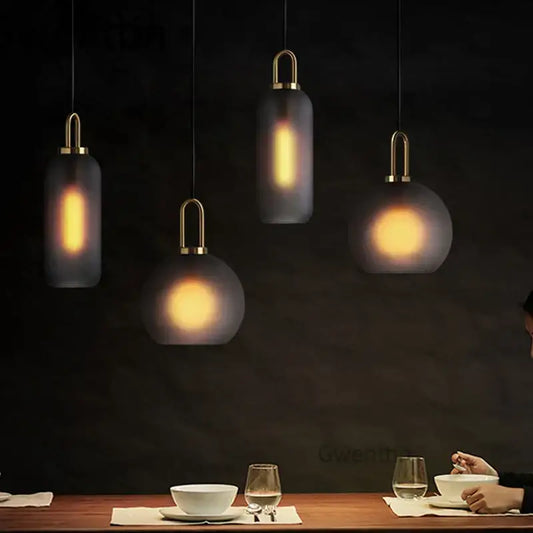 Modern decorbites luxe glass ball pendant lights with frosted glass shades and brass accents above dining table