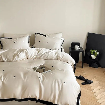 Cream-colored 100% lyocell bedding set with luxe heart embroidered design and black trim from DecorBites™