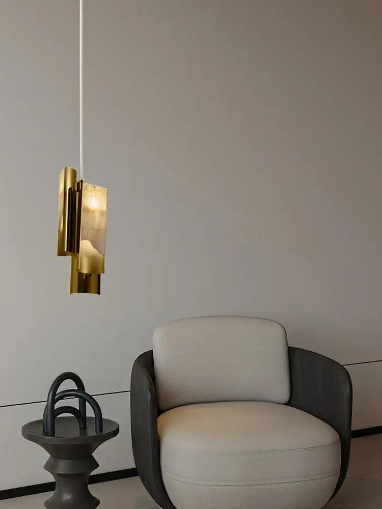 A modern gold-toned decorbites luxe marble pendant light with layered geometric design hangs from ceiling