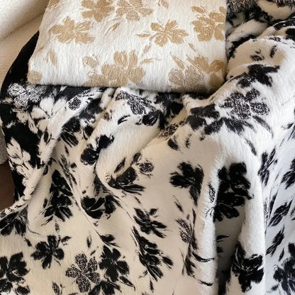 A plush black and white floral-patterned decorbites luxe mink fur jacquard throw with a soft textured surface