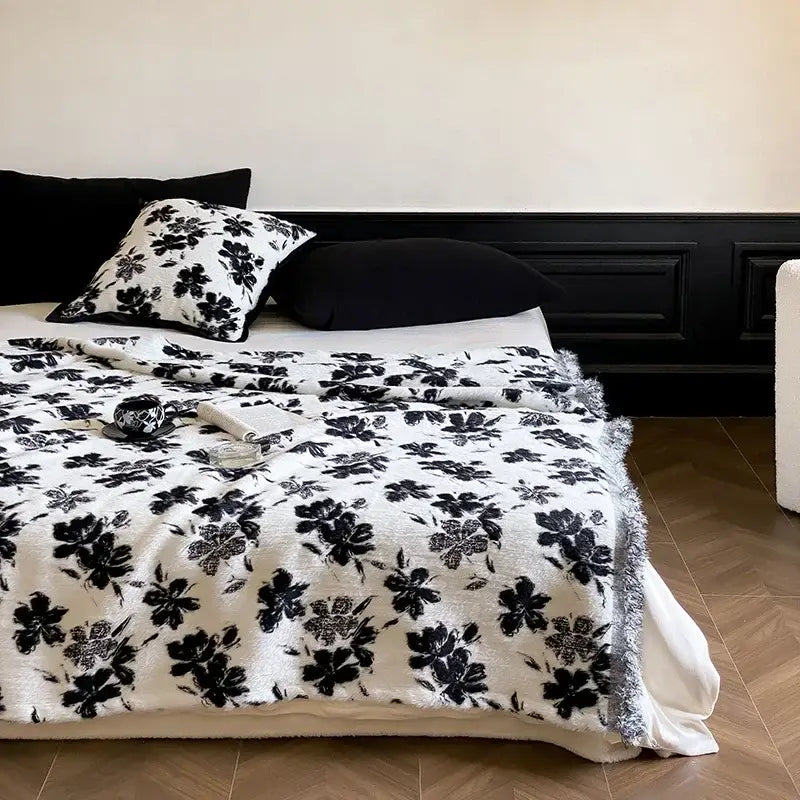 White plush decorbites luxe mink fur throw with black floral pattern and fringed edges for cozy warmth and style