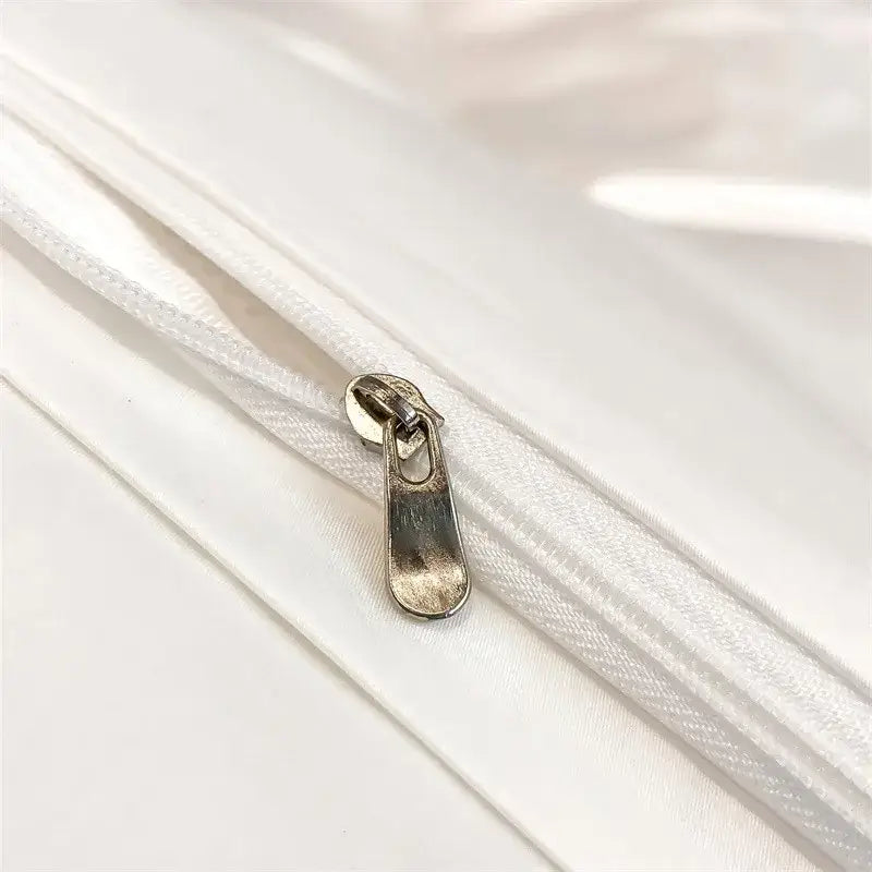 Silver-toned zipper pull on white fabric zippered seam of decorbites luxurious 1000tc egyptian cotton duvet cover