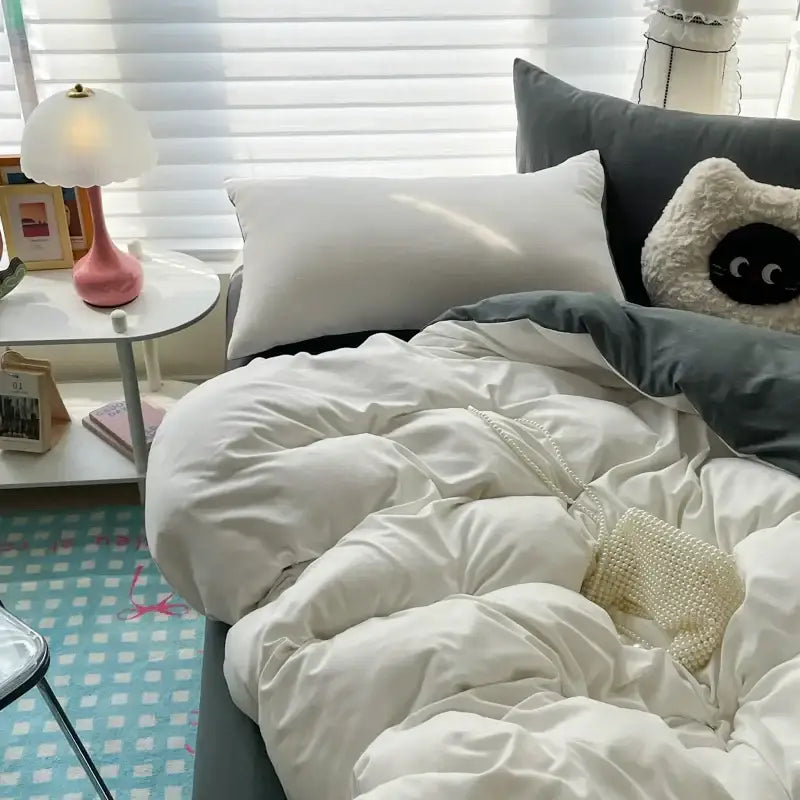 A cream-colored beaded mesh handbag resting on a white cotton bedding set with a duvet cover from decorbites™