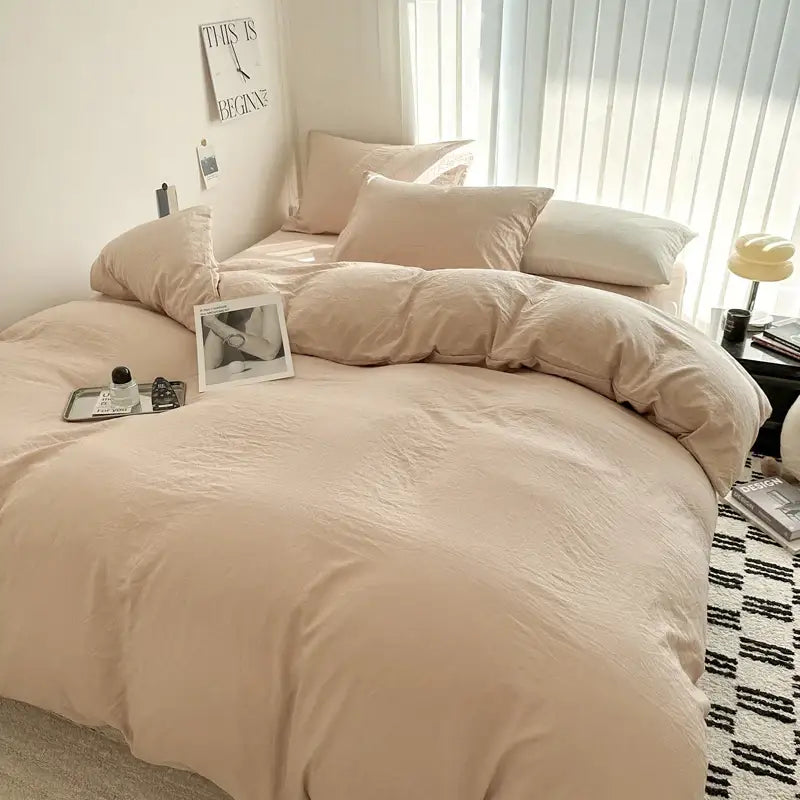 Beige soft-textured cotton bedding set with duvet cover and matching pillows neatly arranged on a bed by decorbites
