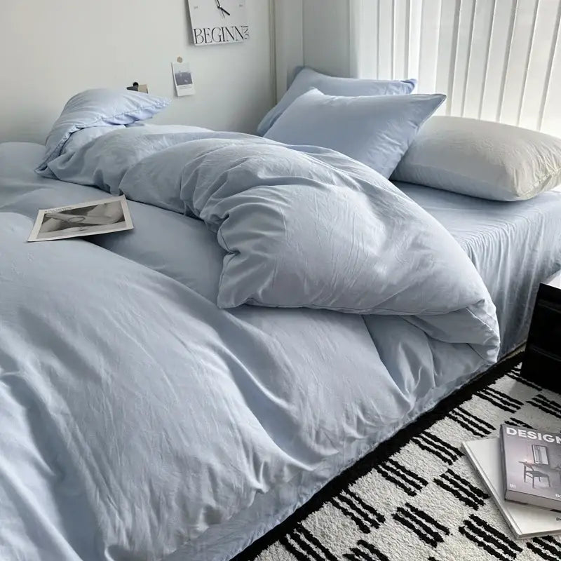 Light blue soft-textured cotton bedding set by DecorBites with matching pillows and a slightly rumpled duvet cover
