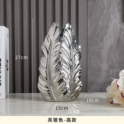 Shiny silver leaf-shaped ceramic vase complementing luxurious gold ceramic vases for elegant home decor