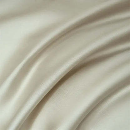 Cream-colored satin duvet cover with smooth glossy finish and gentle folds in decorbites luxurious lyocell silk bedding set