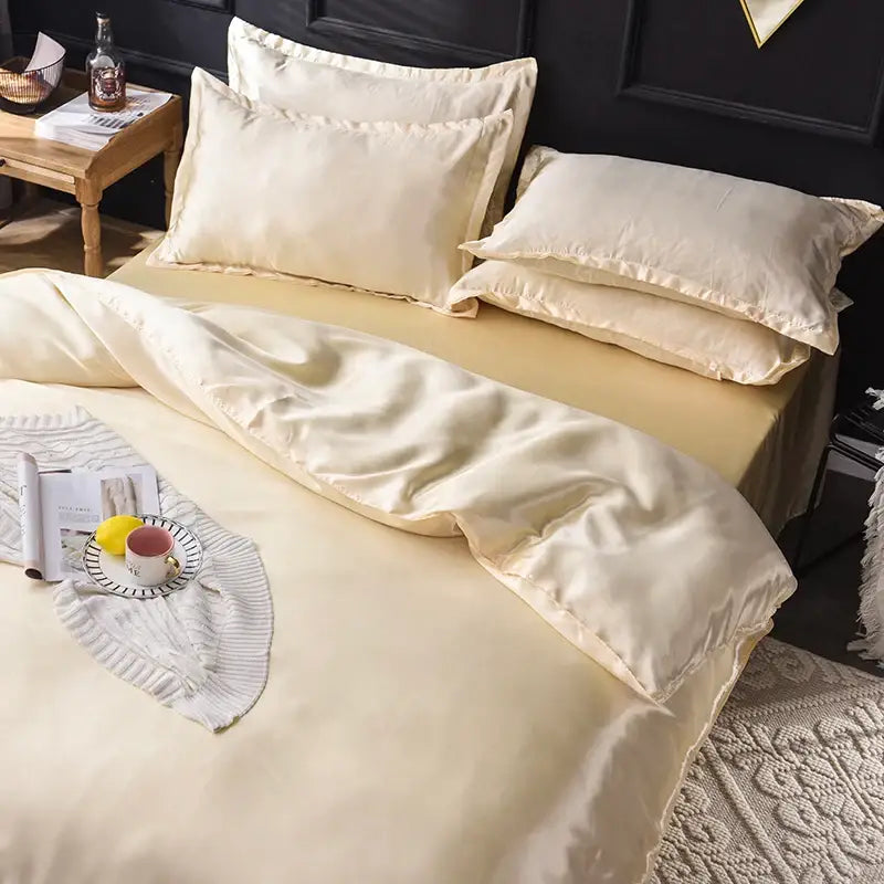 Cream-colored satin silk bedding set by decorbites with smooth glossy finish and elegant stitched edges for all bed sizes