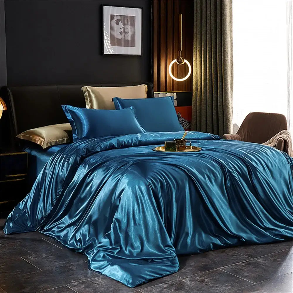 Luxurious teal satin silk duvet cover set with matching pillowcases and gold-trimmed accent pillows by decorbites