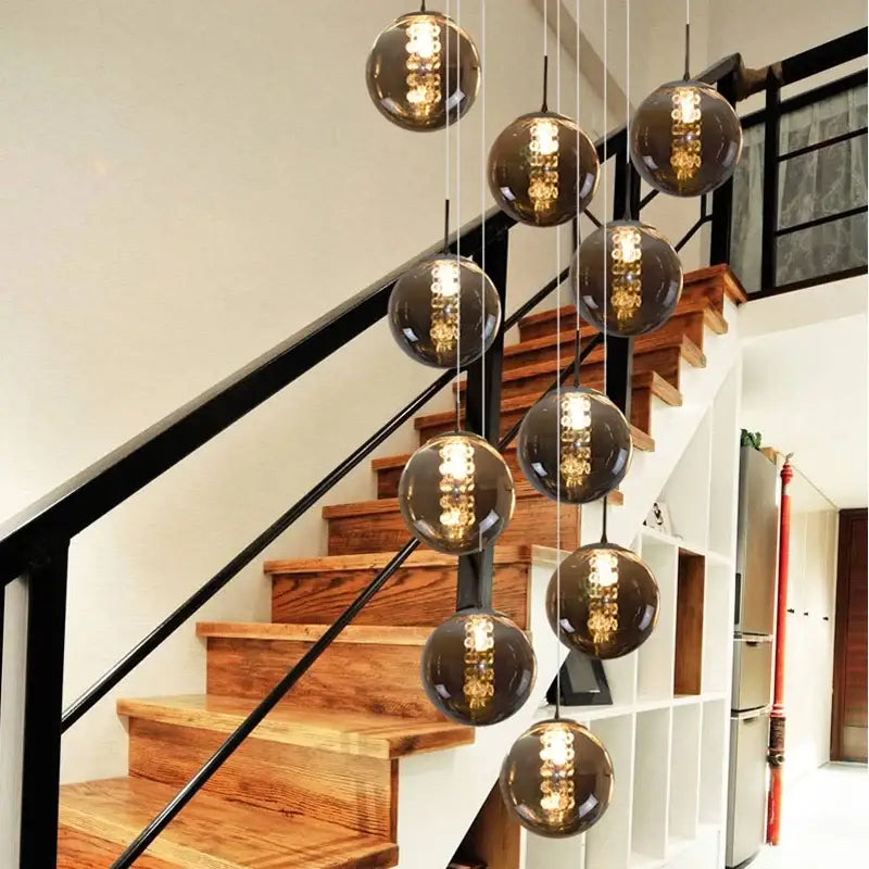 The decorbites™ luxurious spiral led chandelier features sleek dark smoked glass spherical pendant lights with visible filaments for modern loft chandelier settings
