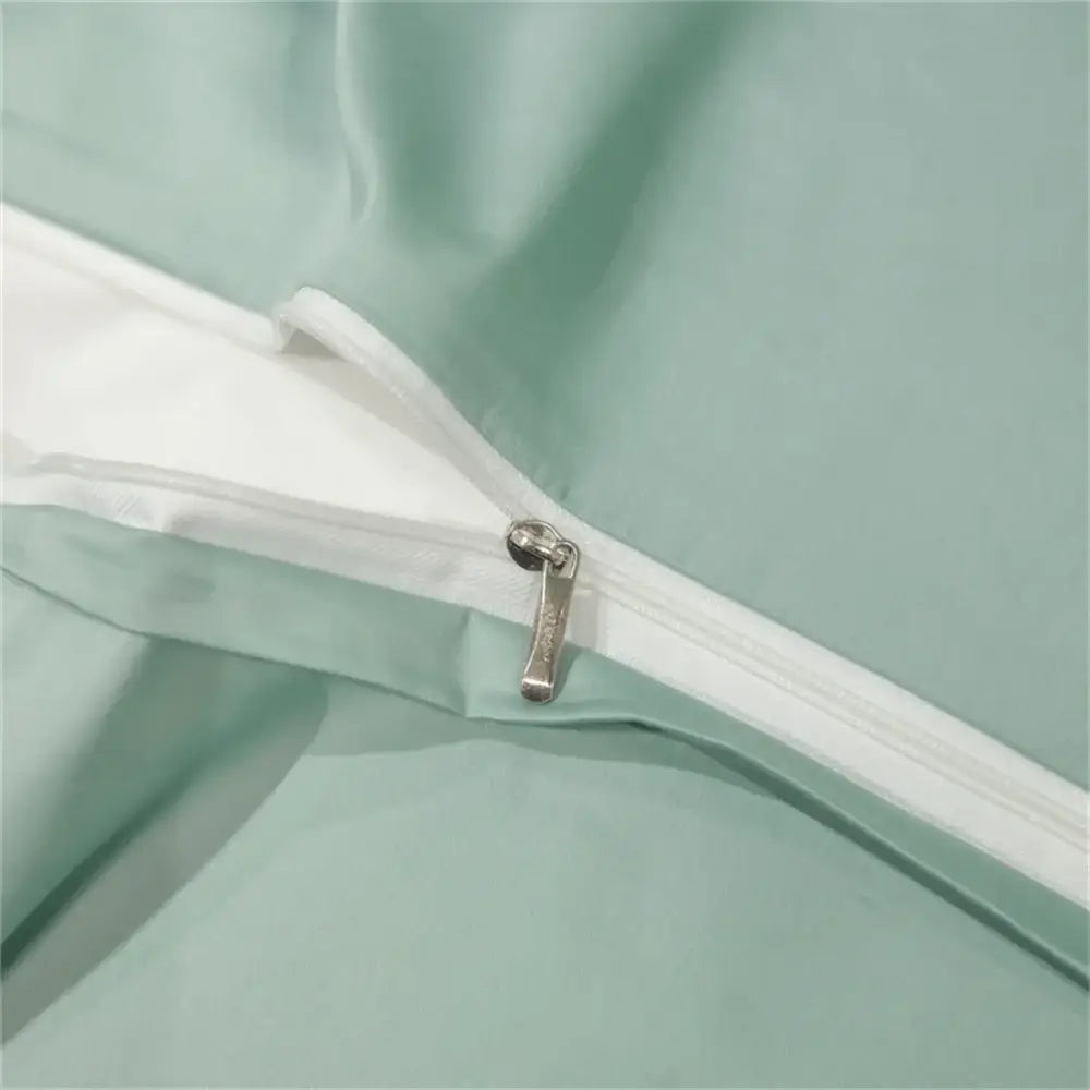 A sleek silver zipper on a mint green egyptian cotton duvet cover from the DecorBites™ luxury bedding set