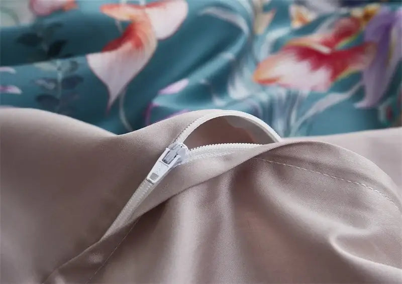 Beige satin pillowcase with white zipper closure from DecorBites™ luxury egyptian cotton duvet cover set against teal floral fabric background