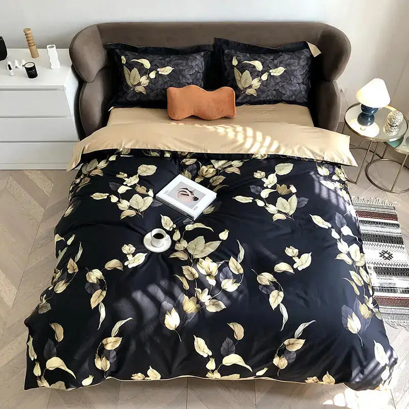 Black satin duvet cover with gold leaf pattern and matching pillowcases plus orange accent pillow in egyptian cotton