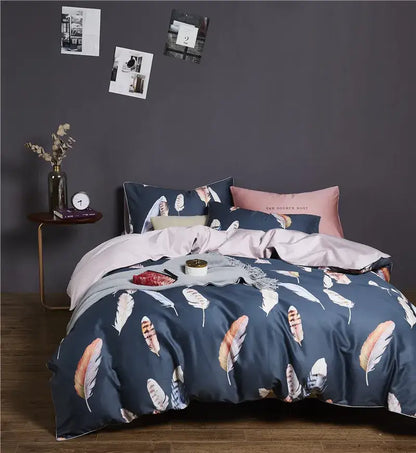 Navy blue feather-print duvet cover set with coordinating pink and beige pillowcases made of luxury egyptian cotton