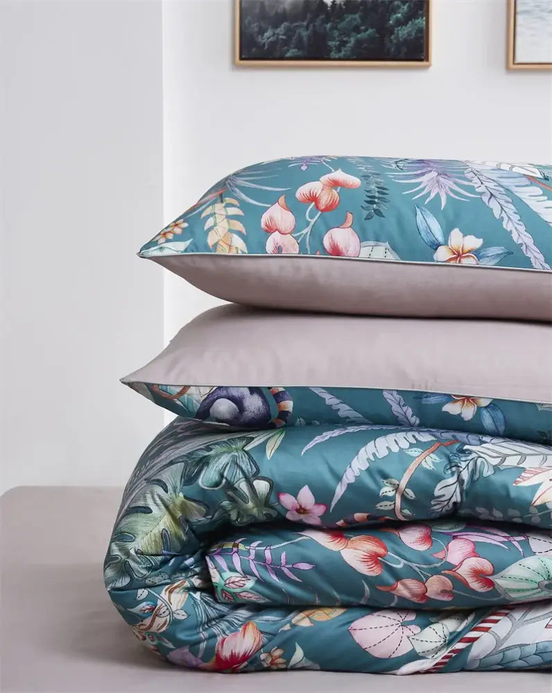 Teal floral-patterned duvet cover with pink blossoms and green leaves made of luxury egyptian cotton by decorbites