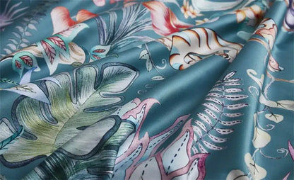 Teal satin duvet cover and pillowcases with vibrant tropical flamingo leaf print in luxury egyptian cotton fabric