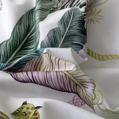 White fabric duvet cover and pillowcases with vibrant tropical print of green banana leaves zebra and pink tiger stripes made of egyptian cotton