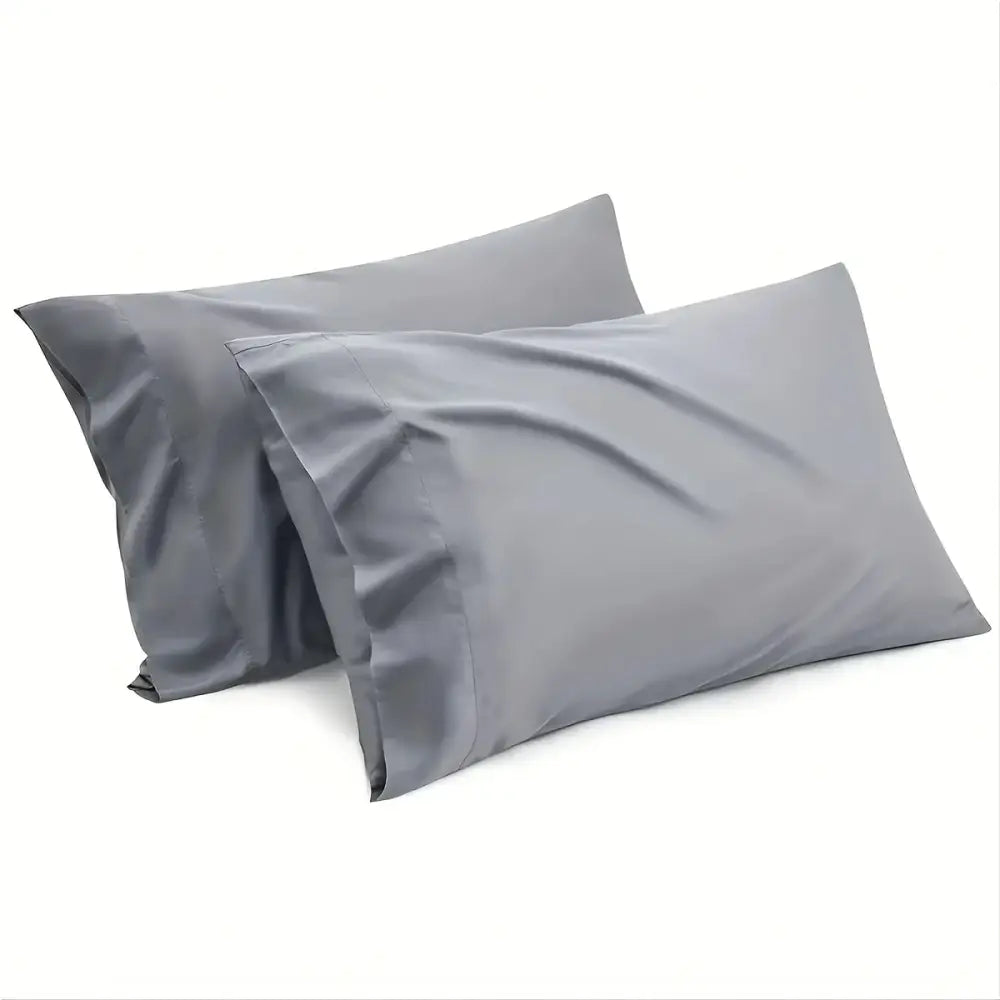 Two matching gray pillowcases from decorbites luxury hotel bed sheet set with smooth, shiny fabric finish