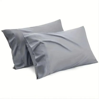 Two matching gray pillowcases from decorbites luxury hotel bed sheet set with smooth, shiny fabric finish