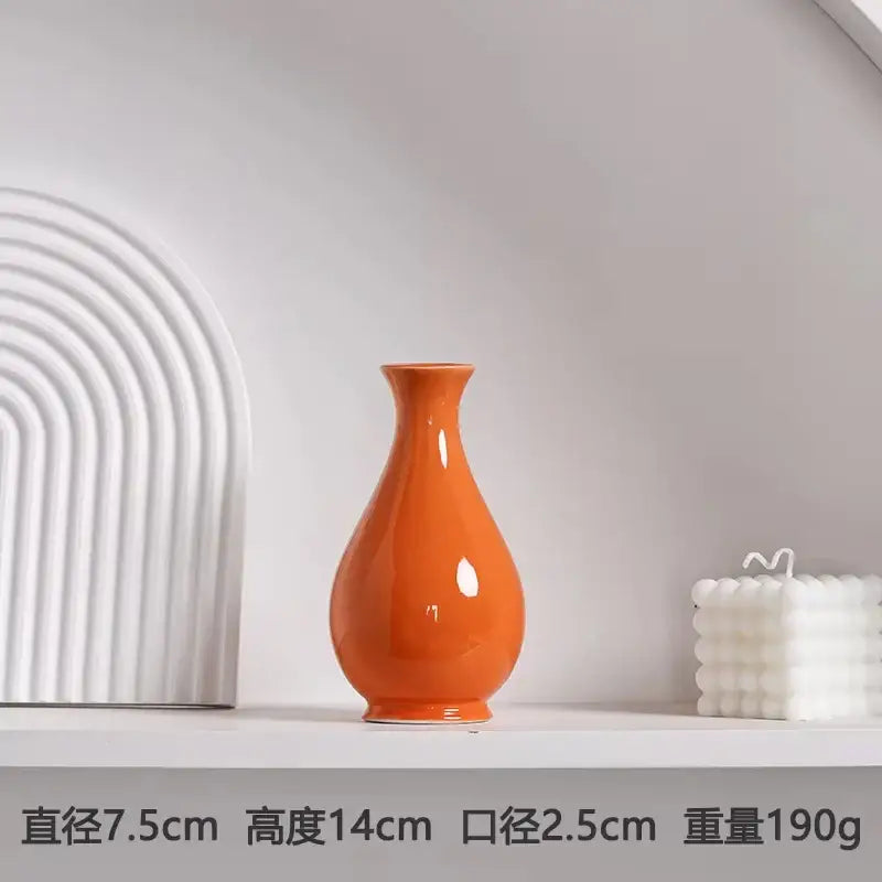 DecorBites luxury modern ceramic flower vase in glossy orange with a slender neck and rounded body