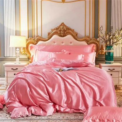 Pink satin mulberry silk bedding set with matching quilt and pillows and ornate gold headboard for queen king size