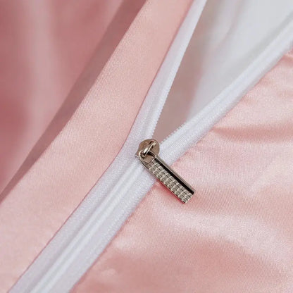 Silver-toned zipper pull with grid texture on soft pink satin fabric of decorbites luxury solid color pcduvet cover