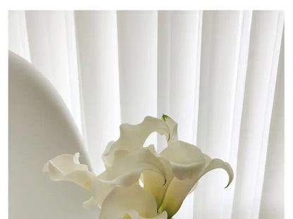A delicate bouquet of white calla lilies in a luxury stainless steel vase by decorbites for elegant home decor