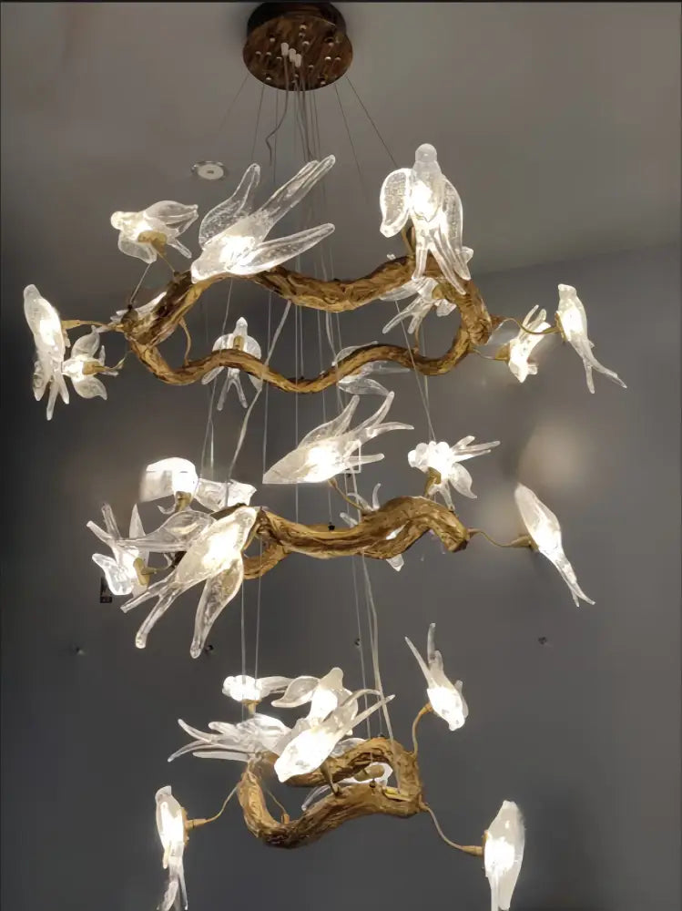 DecorBites luxury vintage glass bird chandelier with translucent glass birds perched on rustic golden brown wooden branches