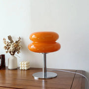 Vibrant orange glossy glass macaron lamp with stacked rounded design and chrome base by italian designer table lamp