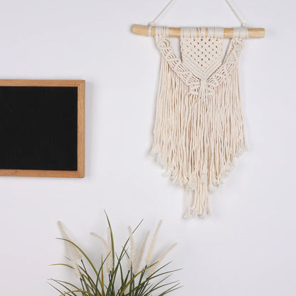 Cream-colored macrame wall hanging with wooden dowel and fringe for chic bohemian decor by DecorBites