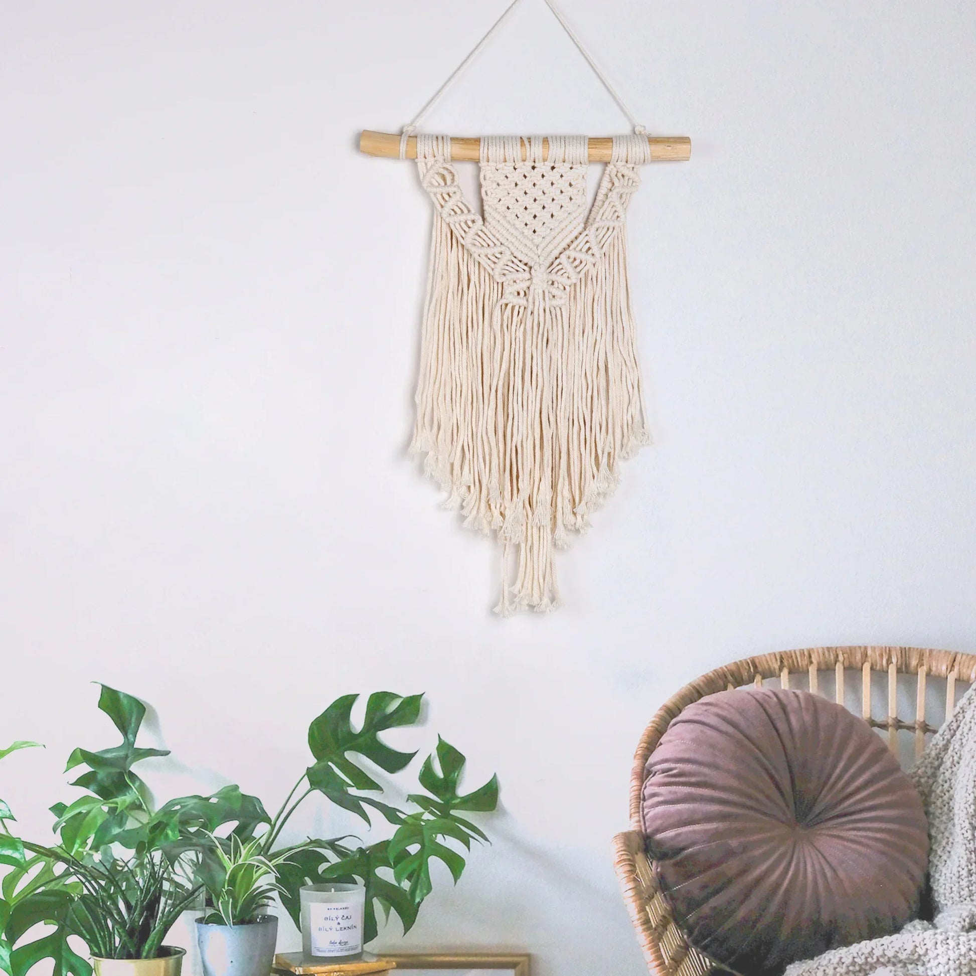 Cream-colored DecorBites™ chic bohemian macrame wall hanging with wooden dowel and fringe for home or dorm decor
