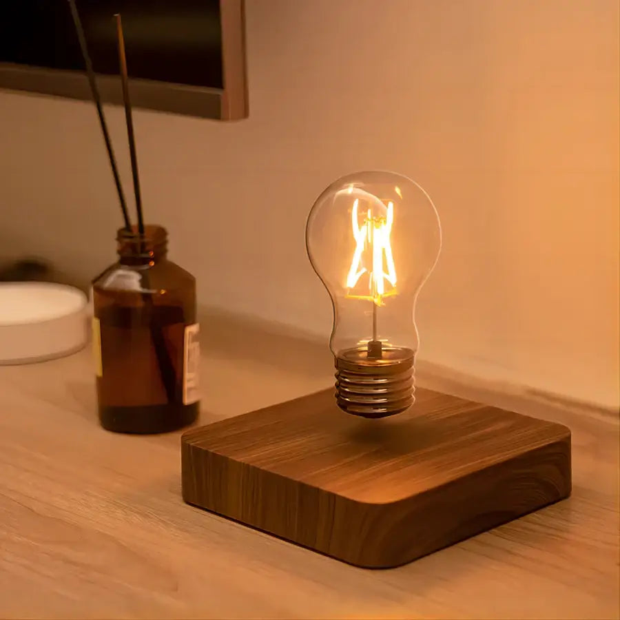 A warm glowing edison-style bulb with visible filament floats above a wooden base in a decorbites magnetic levitation lamp