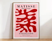 A decorbites™ matisse floral art poster with bold red botanical cut outs on pink in a minimalist wooden frame