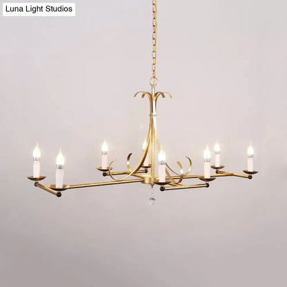 Gold-finished metal island chandelier light with six traditional candle bulbs and central crystal drop by DecorBites